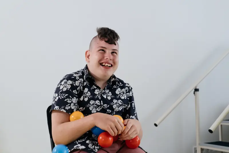 happy-teenage-cerebral-palsy-child-over-white-wall